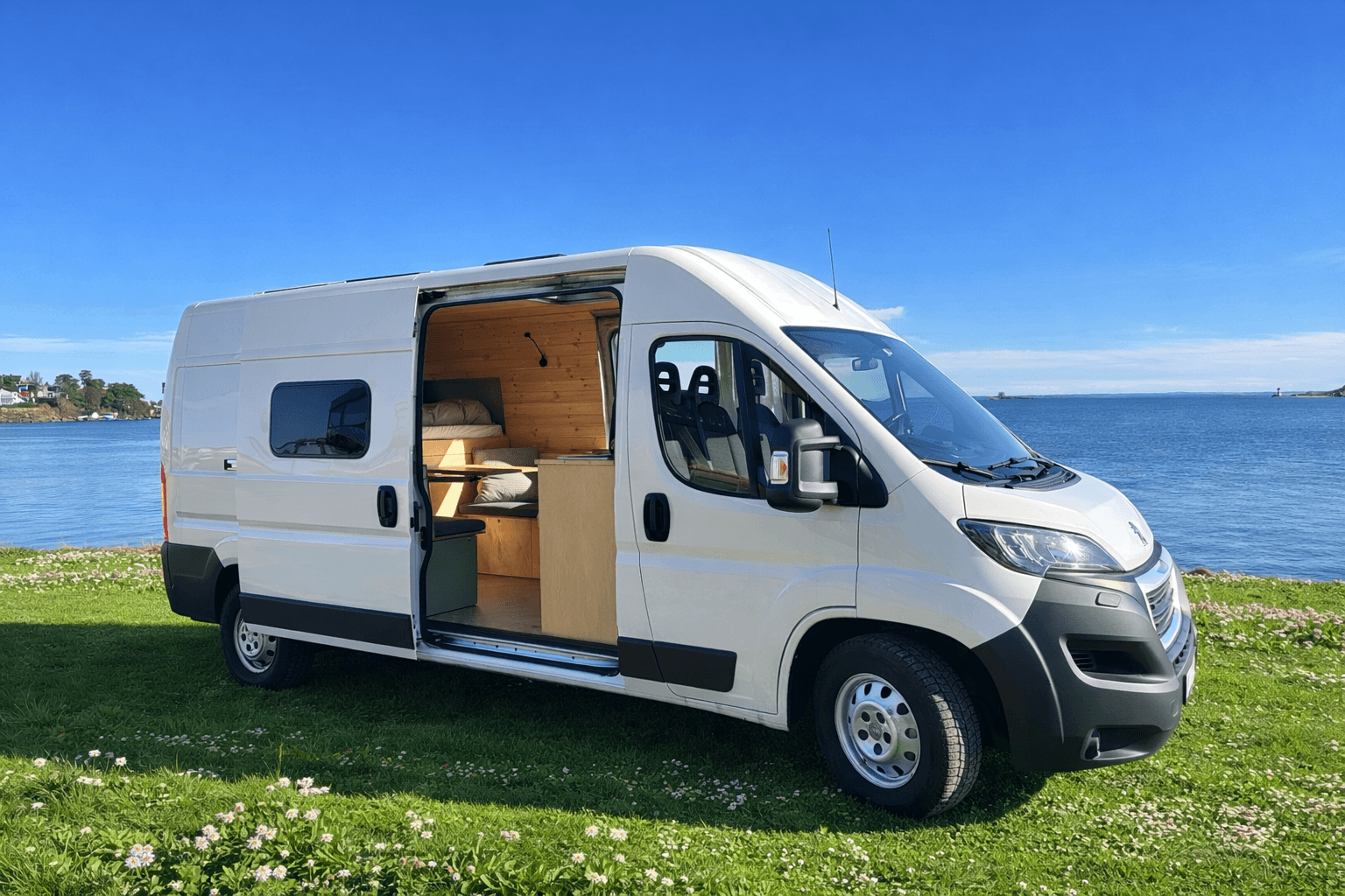 Campervan parked by the sea with the sliding door open
